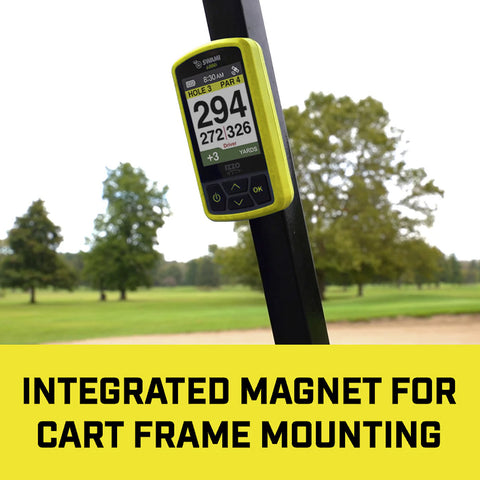 A golf distance measuring device is mounted on a cart frame displaying hole information and yardage amidst a green golf course with trees in the background. INTEGRATED MAGNET FOR CART FRAME MOUNTING