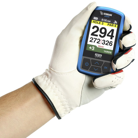 A gloved hand holds a blue golf GPS device displaying distance information for a golf hole including yardage and par while showing the current score and time