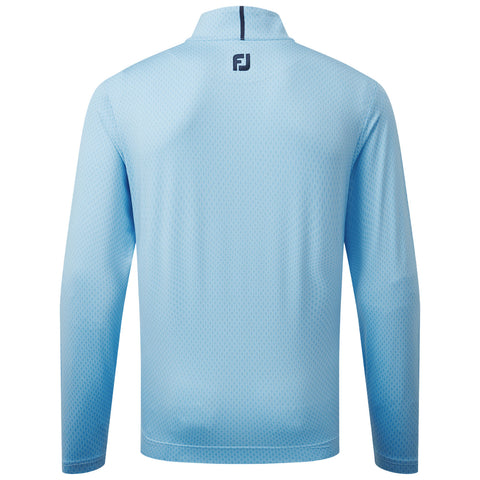 A long-sleeve, light blue athletic shirt made of a breathable fabric is displayed. It has a high collar and features a small logo on the back, positioned centrally.