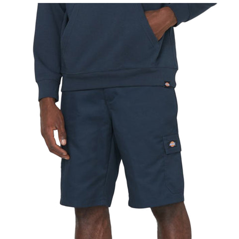 Blue shorts with side pockets are worn by a person standing with one hand on the pocket while the other is relaxed at the side in a neutral setting.