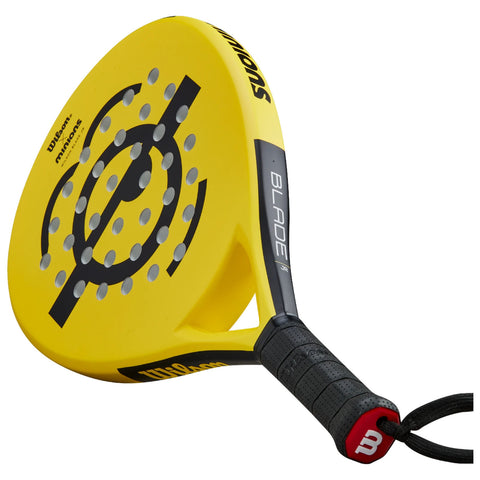 A yellow paddle with a perforated surface and a black handle is positioned at an angle, designed for paddle sports. The paddle features branding and a streamlined design for optimal performance.