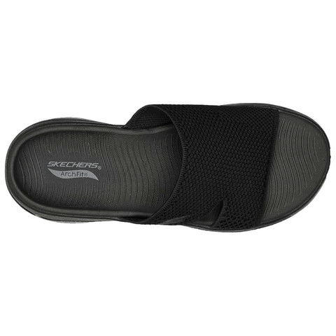 A black Skechers sandal is displayed from above featuring a wide mesh strap and textured sole with the brand name and "Archfit" printed inside the footbed.