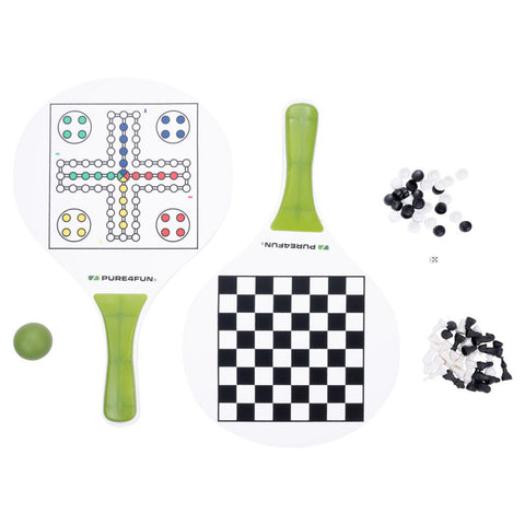 Two game paddles featuring a Ludo board and a checkers board rest on a white surface alongside a green ball and scattered black and white game pieces