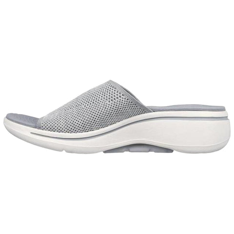 A grey slip-on shoe with a mesh upper and a thick white sole sits on a flat surface showcasing its stylish design and comfort-focused construction.