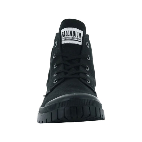 Black high-top shoe stands upright displaying a lace-up front and rubber sole in a simple, uncluttered setting emphasizing its design and branding with label visible on the tongue