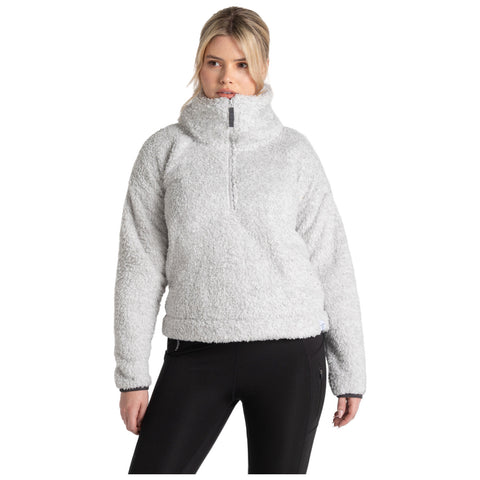 A woman wearing a cozy light gray fleece pullover stands confidently with her hands at her sides in a simple indoor setting showcasing a casual and relaxed style.