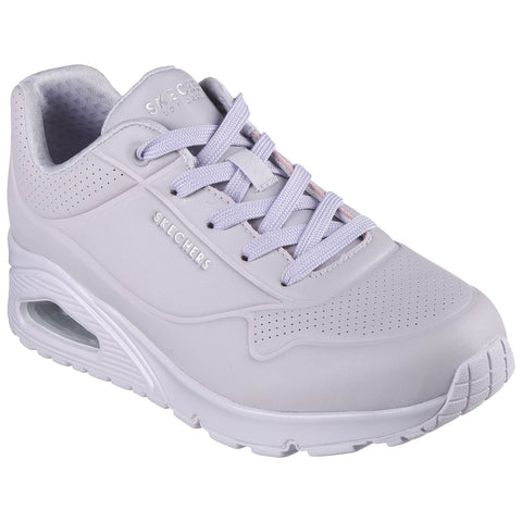 A light gray sneaker is positioned upright showcasing its smooth surface and perforated details. The shoe features matching laces and a cushioned sole with visible air cushioning at the heel.