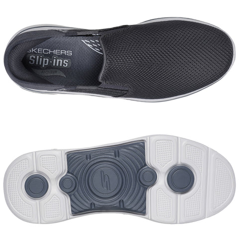 A black Skechers slip-on shoe is positioned with the top view showing a mesh design and branded insole while the bottom view reveals a textured white sole for grip and support.