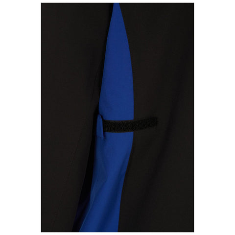 A clothing item features a black exterior with a blue panel hidden underneath it a small flap secured with a black elastic strap is visible on the side