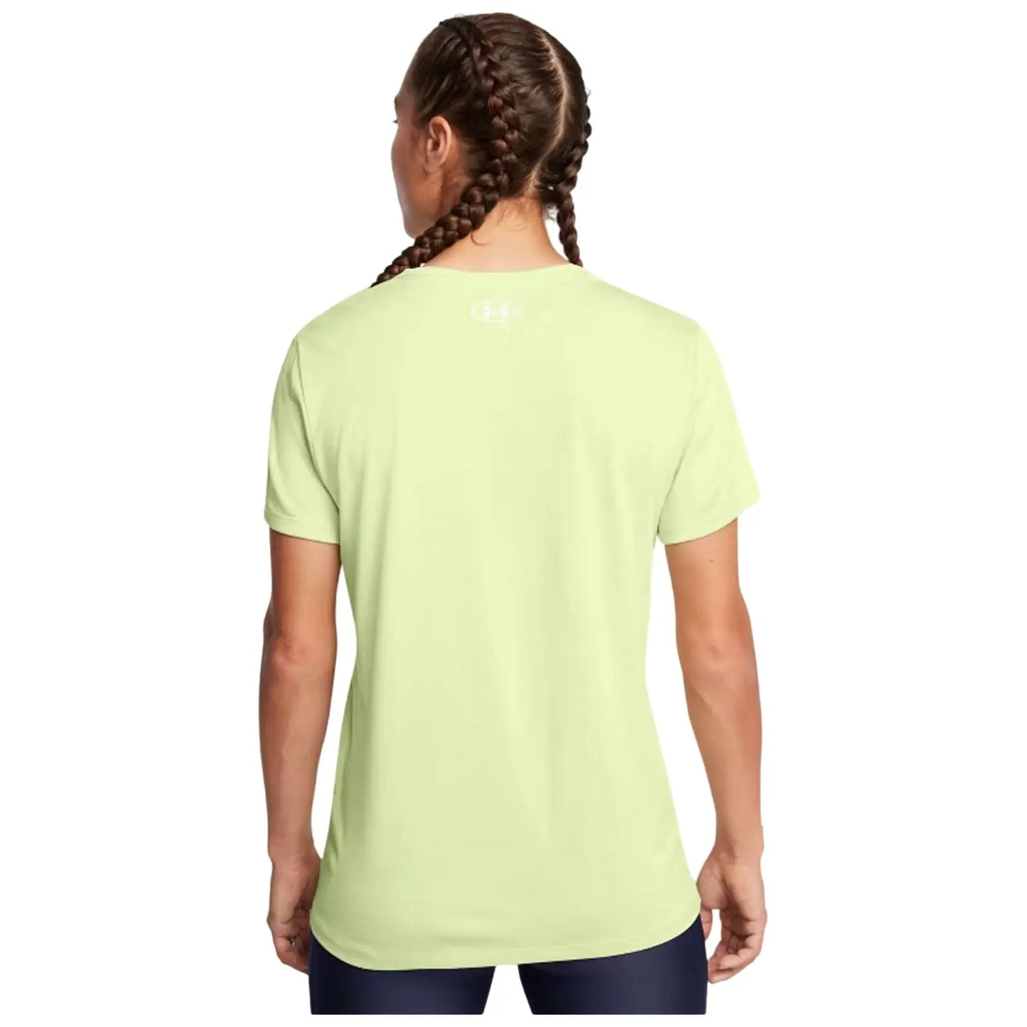 A person with braided hair wears a light green athletic t-shirt facing away from the viewer in a simple, unobtrusive space.