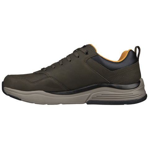 A pair of athletic shoes sits upright showcasing a dark olive green surface with black accents and a yellow interior demonstrating a casual and sporty design suitable for everyday wear.