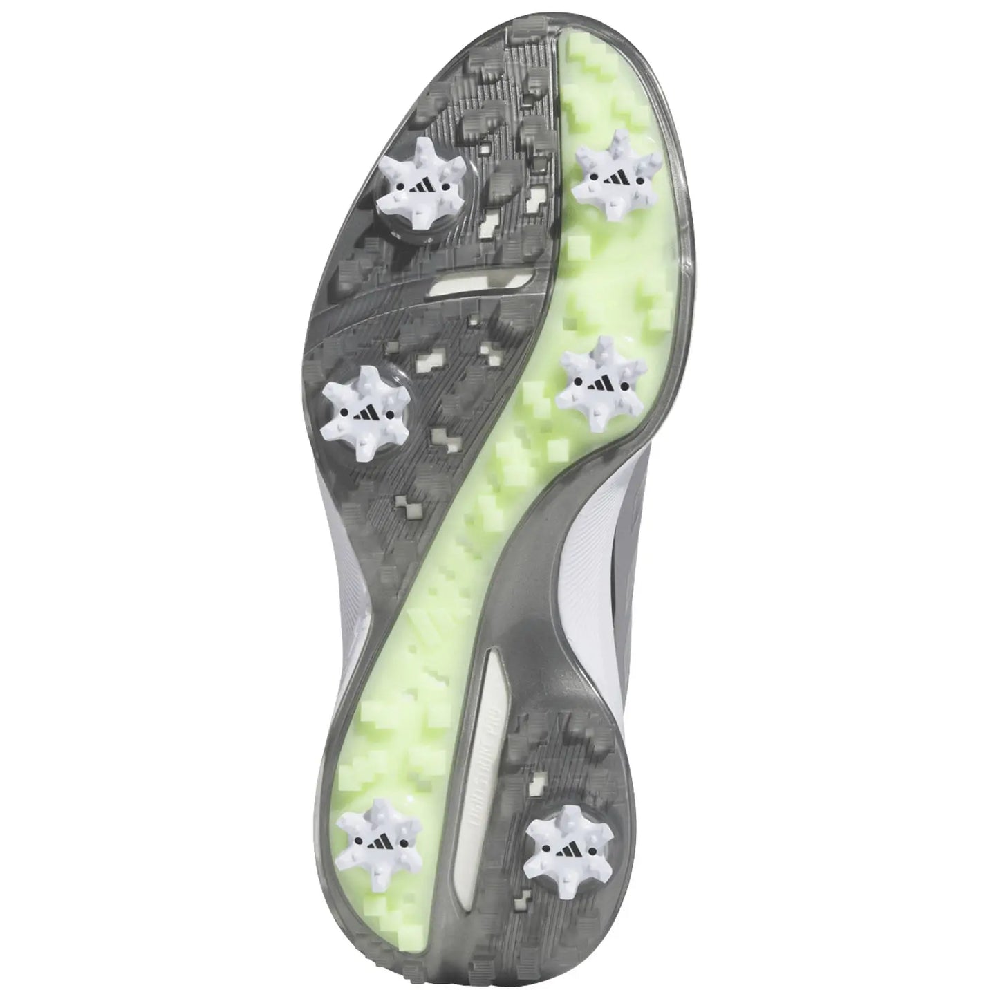 A golf cleat is positioned upside down showcasing its textured sole featuring multiple white studs and a bright green accent designed for traction on the playing field.