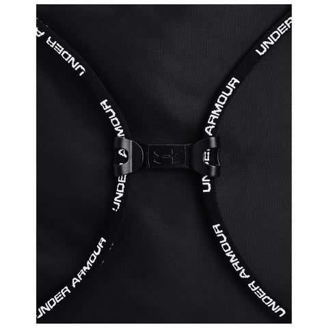 A black backpack features a clasp with adjustable straps displaying "UNDER ARMOUR" text the bag is positioned flat showing its design and closure mechanism.