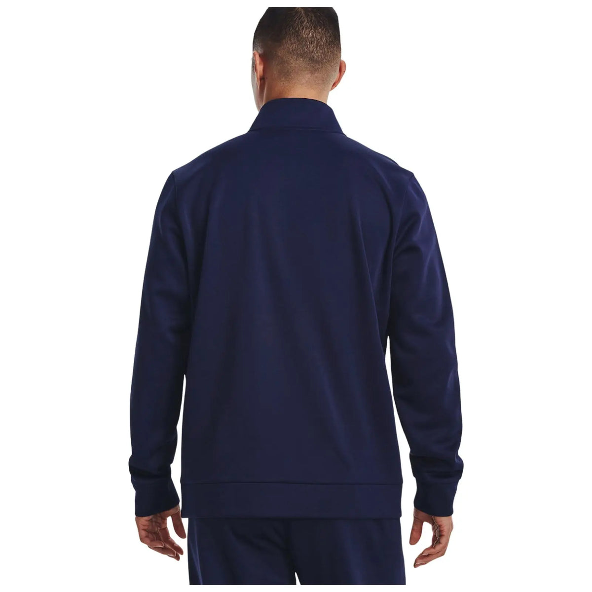 A person is standing with their back facing the viewer wearing a navy blue jacket with a collar in a plain white background. Their hands rest at their sides.