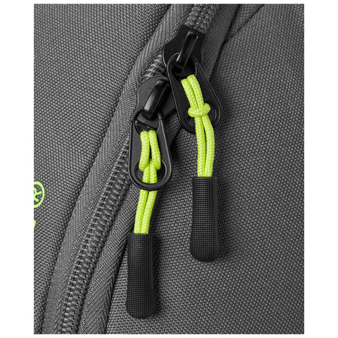 A gray backpack features two zippers with bright green pull cords Both zippers are shown closed against a textured fabric background indicating a durable material used for the backpack