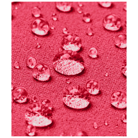 Water droplets gather on a textured pink fabric surface showcasing a close-up view of the interplay between liquid and material in a vivid, colorful context.