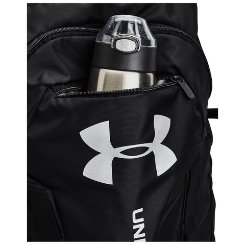 A black backpack features a water bottle in an external zippered pocket. The water bottle has a silver insulated body and a clear lid with a push button. The backpack displays a large white logo.