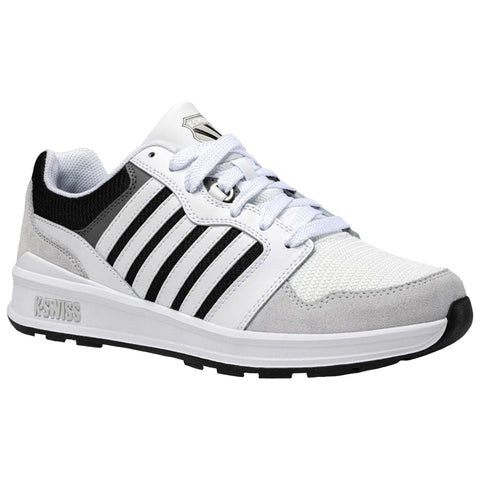 A sneaker is positioned on a flat surface showcasing a predominantly white design with black and gray accents featuring a textured upper mesh and a rubber outsole with patterned tread.