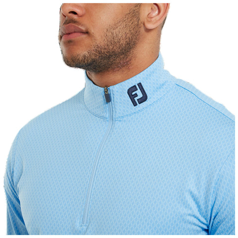 A collar zip-up shirt in light blue worn by a man with short hair and facial hair is displayed. The shirt features a textured pattern and a logo at the collar.
