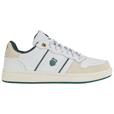 A white sneaker with green accents features two horizontal stripes and a logo on the side while resting on a plain surface in a neutral environment.