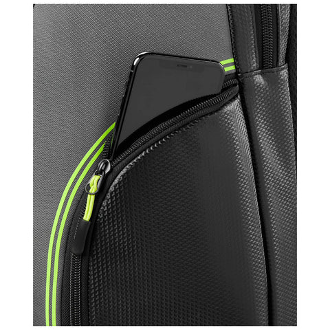 A black smartphone is partially inserted in a zippered pocket of a textured black backpack with a green stripe highlighting the pocket’s edge against a gray fabric background.