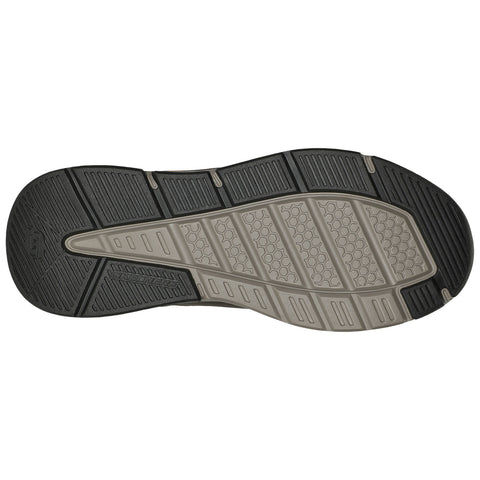 The shoe sole features a patterned design with differing textures for traction and grip resting on a plain background highlighting its details and functionality.