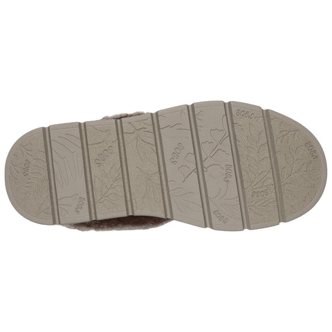 A shoe sole is presented flat and facing up showing textured patterns and imprints with leaf designs and the brand name Bogs visible prominently in sections of the sole.