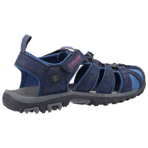A navy blue sandal features a strappy design with a rugged sole and adjustable straps providing comfort and support suitable for outdoor activities in a casual setting.