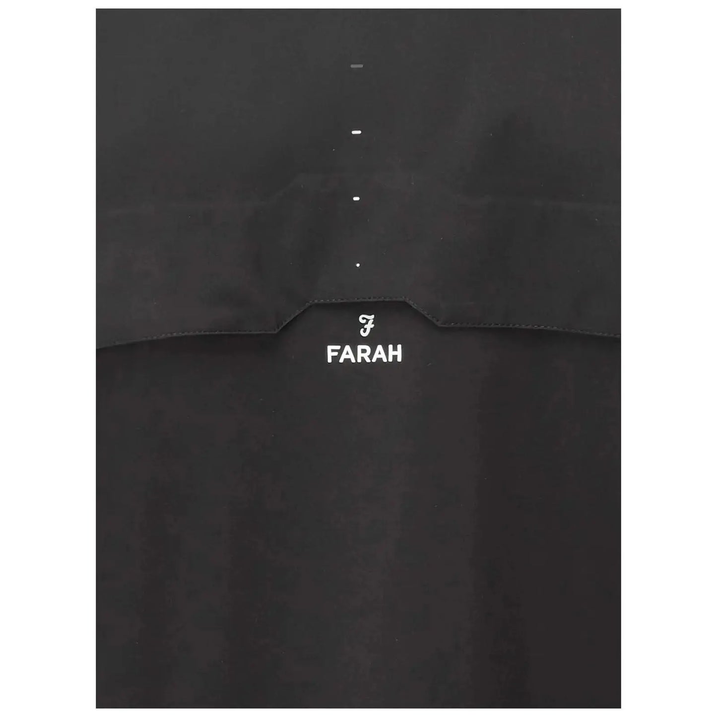 A black garment featuring a small logo and the word FARAH prominently displayed beneath it highlights simple design in a sleek and minimalistic context.