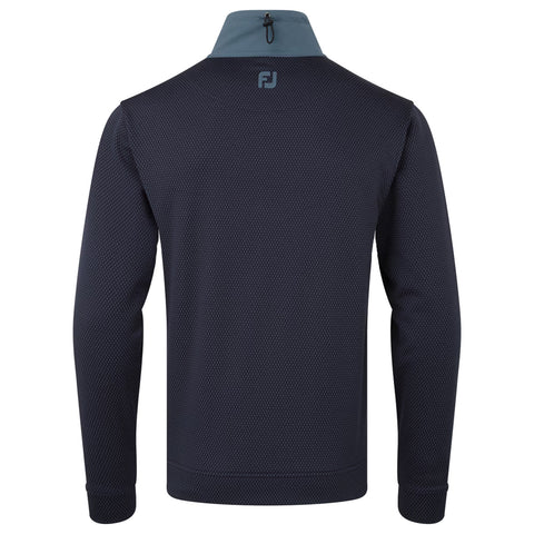 A dark blue long-sleeve pullover stretches across the frame featuring a textured pattern and a high collar with a grey accent at the neck showcasing the logo on the back.
