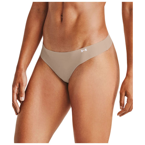 A pair of light beige underwear is displayed fitting snugly around the hips with a logo visible on the front side while a hand reaches toward the fabric.