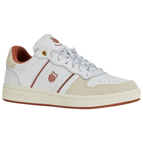 A white sneaker with a suede toe cap has gray laces and red accents on the lining and stripes. It features a logo and is set against a simple background.