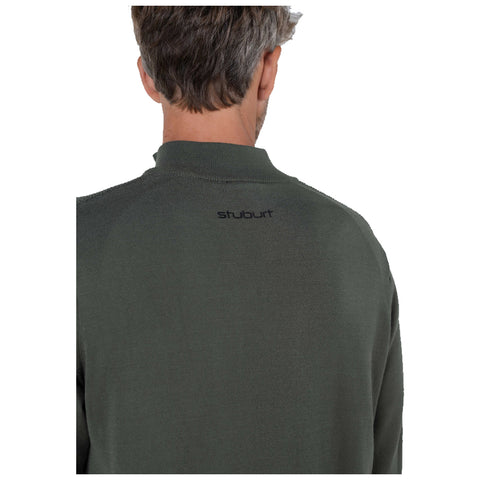 A person with short hair is wearing a dark green sweater featuring a small black logo on the back. The environment appears neutral and unobtrusive.