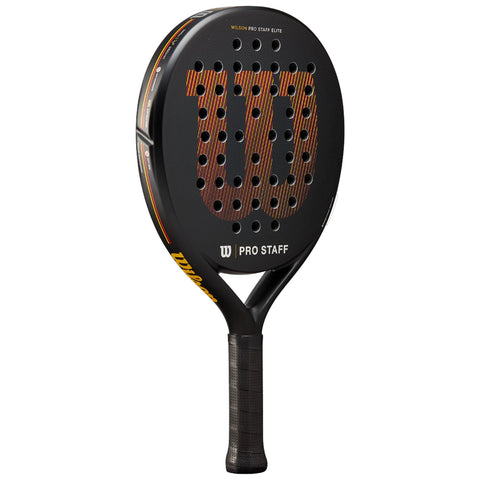 A black padel racket with a perforated surface and a logo reading "WILSON PRO STAFF" is positioned upright against a neutral background, showcasing its sleek design and grip.
