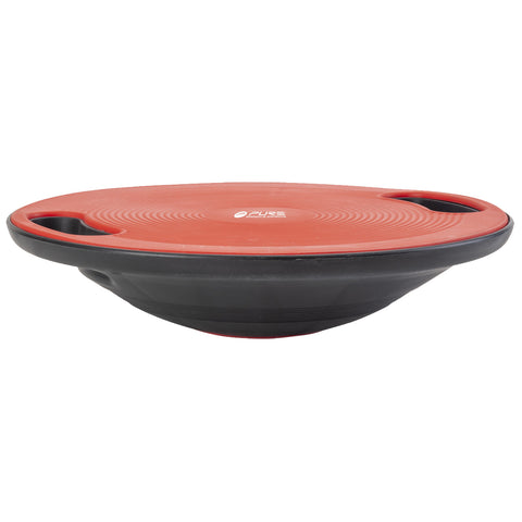 A balance board is positioned horizontally with a red circular top and black bottom featuring two side handles for grip used for stability training and exercise in a fitness environment.