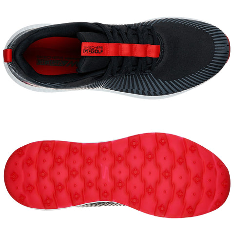 A pair of black golf shoes with a patterned design is shown from above and below. The shoes feature a red strap with "SKECHERS GOCOLF" text and a red rubber sole.