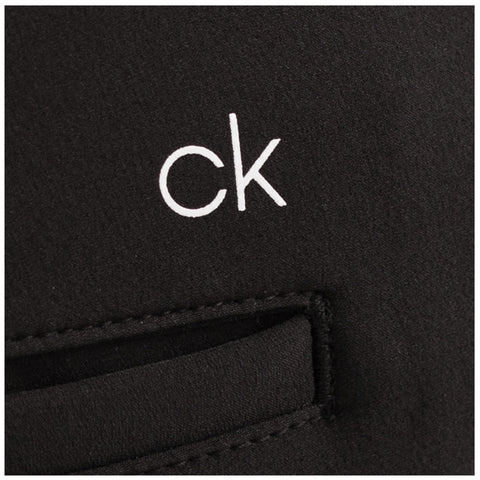 A black fabric features a white logo with the letters "ck" prominently displayed. The fabric has a small opening or pocket area stitched into it.