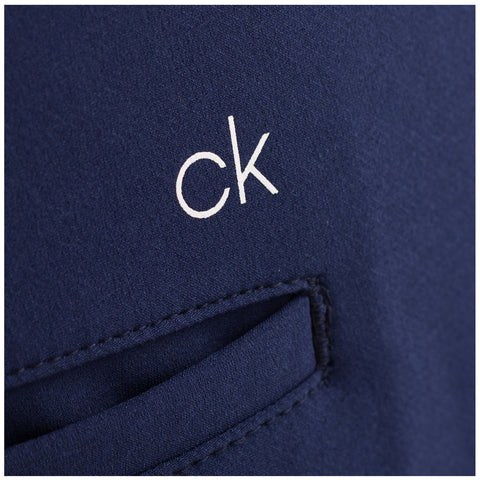 A navy fabric features a white logo reading "ck" positioned near a pocket seam suggesting a clothing item designed for casual or formal wear in a stylish context.