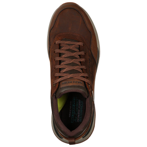 A brown sneaker features a textured surface with laces and a cushioned interior displaying "SKECHERS AIR COOLED WATERPROOF" text, set against a plain white background.