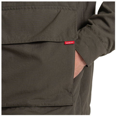 A green jacket with a large pocket is shown with a hand resting inside. A small red tag labeled NOSILIFE is visible on the pocket. The background is plain white.