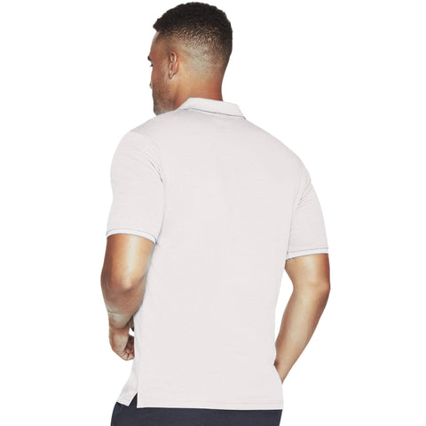 A man is standing with his back to the viewer wearing a light-colored polo shirt with short sleeves and a collar in a simple white background setting.