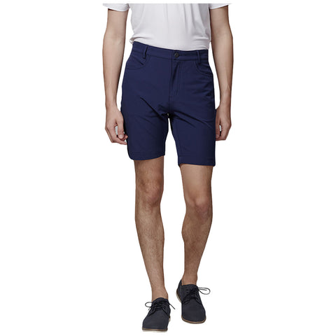 A person is standing and wearing navy blue shorts with a white shirt and dark shoes showcasing a casual summer outfit against a plain white background.