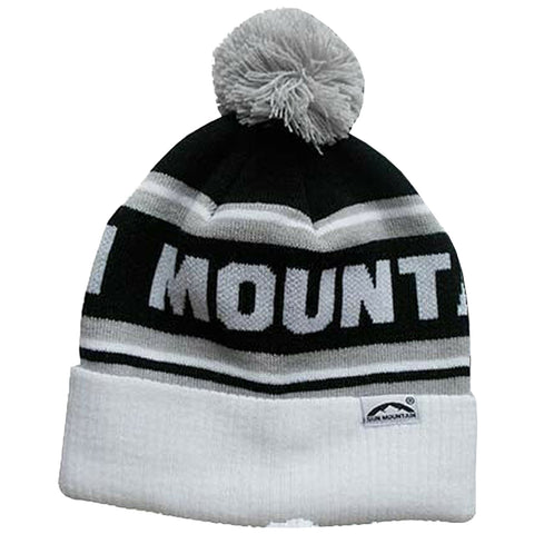 A knit beanie with a white and black color scheme features a large pom-pom on top and displays the word MOUNTAIN prominently across its band, suitable for cold weather wear.