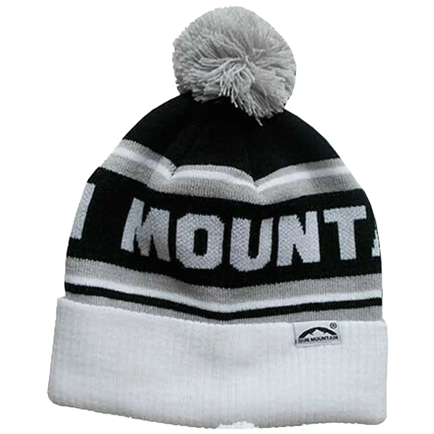 A knit beanie with a white and black color scheme features a large pom-pom on top and displays the word MOUNTAIN prominently across its band, suitable for cold weather wear.
