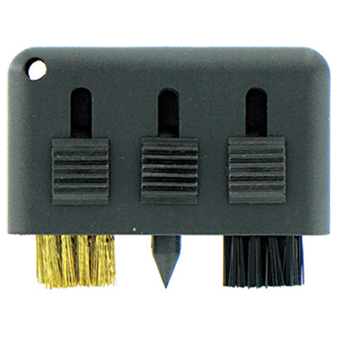 A tool with three different brushes and a pointed tip is positioned on a plain surface used for cleaning or detailing tasks in a workshop or craft setting