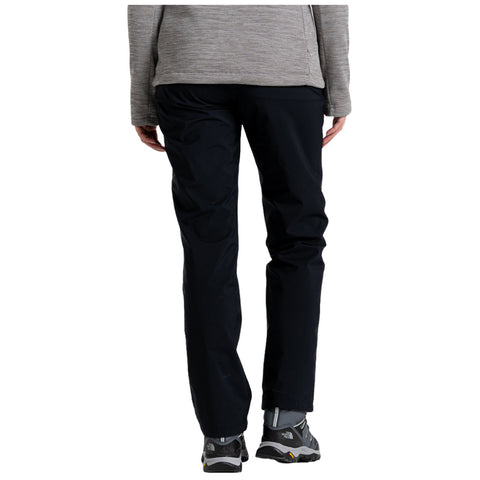 A person is wearing black pants and gray footwear standing upright wearing a gray top which suggests a casual outdoor or hiking context. They are facing away from the viewer.