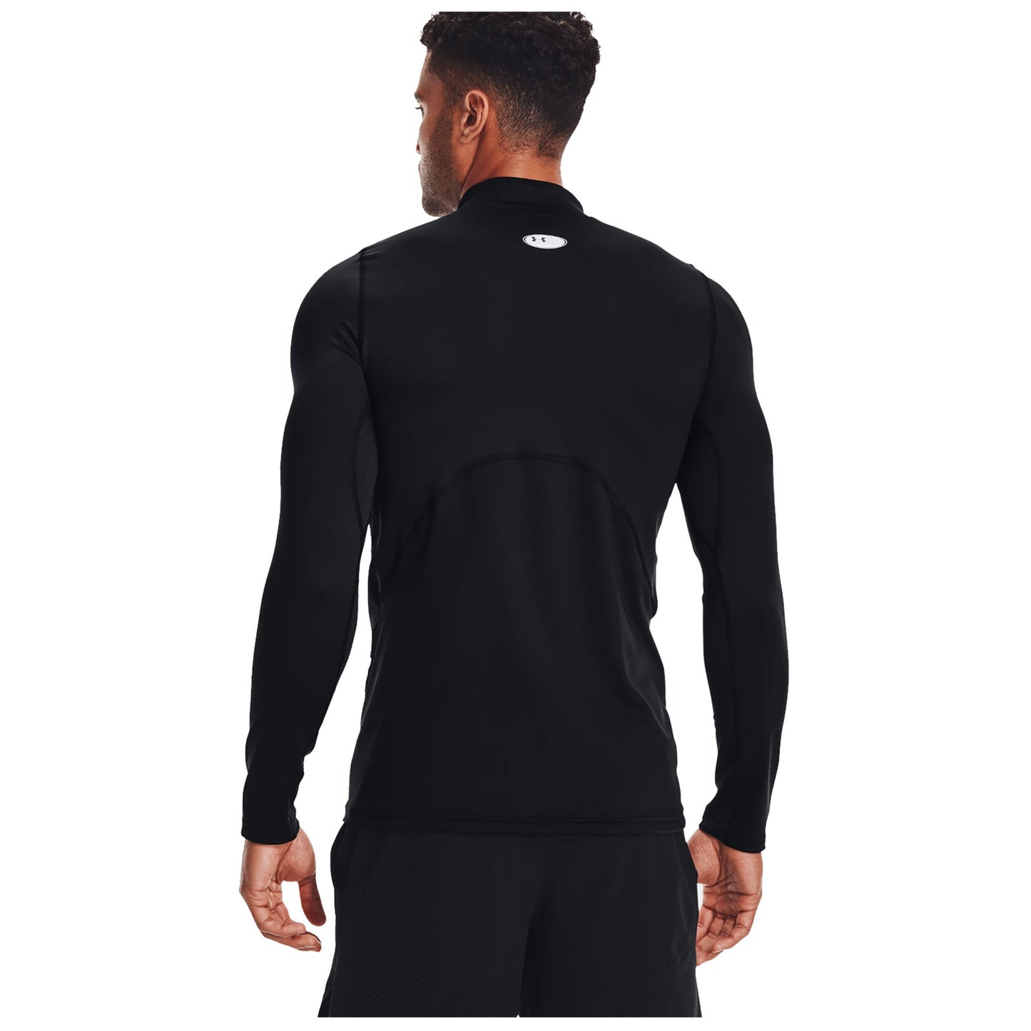 A man stands wearing a fitted black long-sleeve athletic shirt with his back towards the viewer, positioned against a plain white background, emphasizing his sleek silhouette.