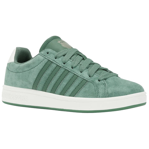 A green athletic shoe with a suede texture features three raised stripes along the side and a white rubber sole placed against a plain background.