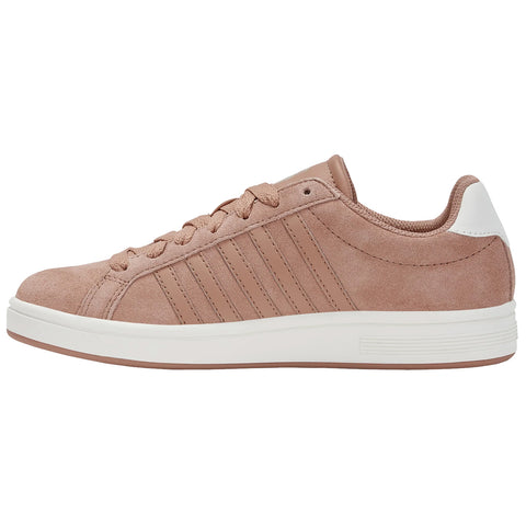 A pink suede sneaker features a white heel and is adorned with three vertical stripes on the side resting on a white rubber sole against a plain background.