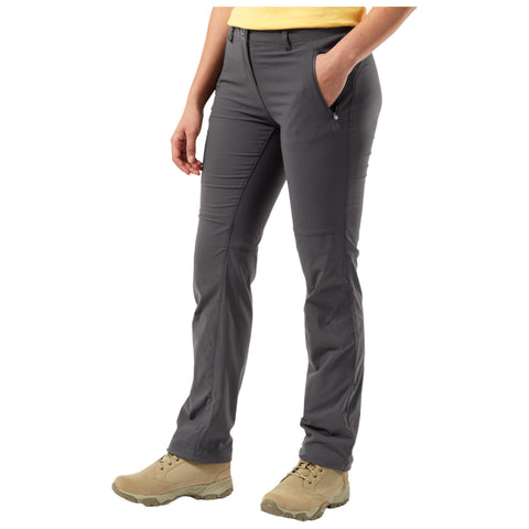 Gray outdoor pants are worn by a person standing with a hand in a pocket featuring a casual yellow shirt and beige boots in a neutral background.